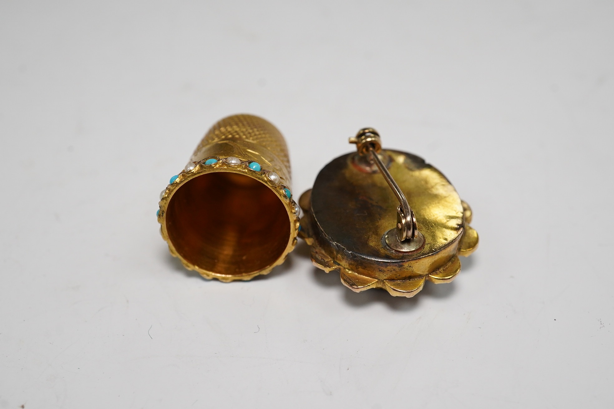 A George V 9ct gold, turquoise and seed pearl set thimble, 5.9 grams, and an amethyst and split pearl set yellow metal clasp, converted to a brooch. Condition - poor to fair